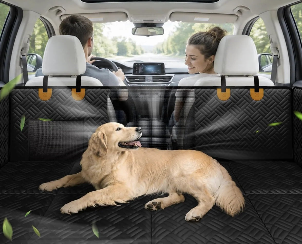 Golden retriever lying on the back seat extender, with the driver and passenger visible through the mesh window
